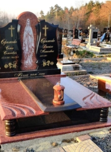Гранітний подвійний пам'ятник на цвинтарі з хрестом та декоративною стелою
