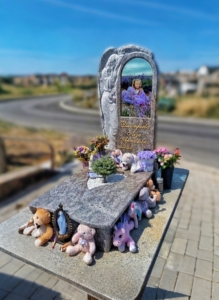 дитячий пам'ятник із граніту з квітами та іграшками, пам'ятник дівчинці фото